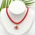Detalle de collar de cordon rojo con colgante ovalado floral esmaltado estilo retro. - Colgante de Rosa Ovalado Con Cordón Rojo