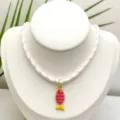 Gros plan du pendentif poisson coloré émaillé à rayures sur un collier en corde tressée. - Pendentif + Chaîne sur la Photo (Q01-19)