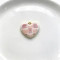 Detailed shot of the elegant enamel heart pendant with red geometric pattern and gold rim. - Red Pattern Retro Style (C01-7)