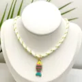 Gros plan détaillé du pendentif poisson émaillé coloré sur un collier en corde blanche. - Pendentif + Chaîne sur la Photo (Q01-16)