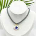 Collar con colgante ovalado de golondrina esmaltada vintage con cadena de cuerda gris. - Colgante Golondrina Ovalado Con Cordón Gris