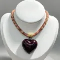 Close-up details of the brown braided rope necklace featuring a glossy dark red heart pendant. - B04 Finished Necklace / Brown and White Cord with Deep Red Heart