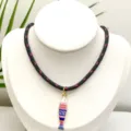 Gros plan détaillé du pendentif poisson coloré et de la texture du collier tressé. - Pendentif + Chaîne sur la Photo (Q01-12)