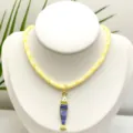 Gros plan détail du collier pendentif poisson rayé style marin avec chaîne tressée jaune. - Pendentif + Chaîne sur la Photo (Q01-10)
