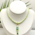 Détail en gros plan d'un collier en corde tressée vert clair avec un pendentif poisson. - Ensemble Pendentif et Chaîne (Q01-9)