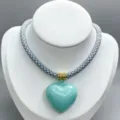 Stylish braided cord necklace featuring a glossy light blue heart pendant and gold rings. - B08 Finished Necklace / Gray and White Cord with Light Blue Heart