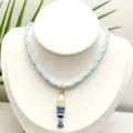 Vue détaillée du collier pendentif poisson rayé coloré de style marin avec corde tressée. - Ensemble Pendentif et Chaîne (Q01-8)