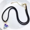 Chic brown cord necklace featuring a white enamel heart pendant with purple roses and gold chain. - Black Necklace Heart Style (C02-1)
