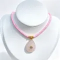 Detailed view of natural rose quartz teardrop pendant with gold accent and pink braided cord. - Pendant With Chain / Pink