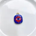 Close-up detail of a blue and red enamel sun eye metal pendant charm for DIY jewelry making. - K01-3 (Pendant Only)