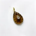 Detailed view of teardrop carved crystal pendant with central zirconia and gold bail accent. - Tiger's Eye Color