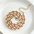 Detailaufnahme einer 3mm geflochtenen Polyester-Halskette mit goldenem Karabiner und Kette. - C01-22