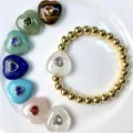 Detailaufnahme des Goldperlenarmbands mit Kristallherzanhänger und bunten Natursteinherzen. - Armband-Stil / Armbandlänge ca. 17cm / J07 Bergkristall (Armband)