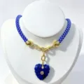 Blue braided rope necklace with carved blue heart pendant and gold metal details detail view. - Blue Pendant Necklace
