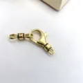 Close-up detail of gold-plated DIY lobster clasp with micro-inlaid black stones for jewelry. - Gold