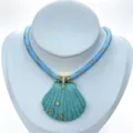 Detailansicht einer blau geschnitzten Muschel-Halskette mit funkelnden Zirkonen und Seilkette. - Halskette (Anhänger Mit Kette) / Blau