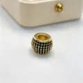 Primo piano dettagliato di una perla distanziatrice dorata con cristalli neri fai da te. - Oro (Strass Nero)