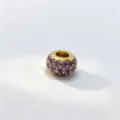 Close-up view of shiny golden micro-pave purple cubic zirconia large-hole charm bead accessory. - Gold (D07)