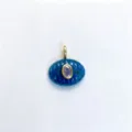 Close-up of blue carved oval stone pendant with purple center zircon and gold bail detail. - Pendant Only (Without Chain) / Blue