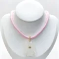 Detailed view of carved crystal tropical fish pendant with zircon and pink cord necklace. - Necklace / Pink