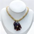 Close-up detail of carved stone fish pendant necklace with zircon and woven cord. - Pendant Necklace Set (U08) / Tan