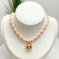 Close-up detail of the golden irregular pendant necklace featuring pink zircon and braided cord. - Necklace (With Pendant and Chain) / Pink Braided Rope