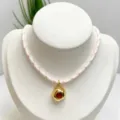Vintage irregular gold plated pendant necklace with red cubic zirconia and pink woven rope chain. - Necklace (With Pendant and Chain) / Pink and White Braided Rope