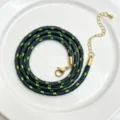 Nahaufnahme der 3mm schwarz-grün geflochtenen Kordelkette Detailansicht mit goldenem Verschluss. - C01-17