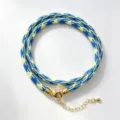 Blue and yellow woven rope necklace detail showing the intricate mesh pattern and golden clasp. - A-11