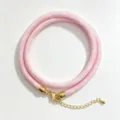 Detail shot of pink woven round rope necklace with golden metal clasp and extension chain. - A-19 Light Pink