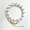 Black and white woven rope necklace with gold hardware detailed shot displaying texture. - A-23