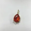 Primo piano del ciondolo in zircone arancione a pera con montatura dorata, dettaglio elegante. - B7-11 Rosso