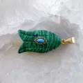 Gros plan detail d'un pendentif en forme de poisson vert avec pierre bleue et attache. - Malachite