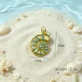 Vue détaillée du pendentif coquillage doré avec incrustations de pierres bleues plage. - Pendentif Conque / Or