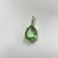 Primo piano dettagliato dell'elegante ciondolo in zircone cubico verde a goccia in oro. - B7-10 Verde