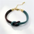 Close-up of the stylish braided couple bracelet featuring dual-color cords and gold metal accents. - Size 6
