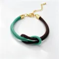 Detail shot of dual-color Milan rope braided bracelet with figure-8 knot and adjustable chain. - Size 11