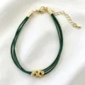 Primo piano del braccialetto intrecciato verde a più fili con ciondolo a trifoglio dorato. - 04# (Verde)