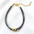 Primo piano dettagliato di un bracciale multistrato in corda nera con perline dorate. - 08# (Nero)