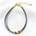 Vista dettagliata del bracciale intrecciato multistrato nero e bianco con ciondolo a farfalla dorata. - 11# (Nero e Bianco)