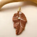 Pendentif feuille en pierre de soleil dorée avec détails scintillants et strass étincelant. - Grès Doré