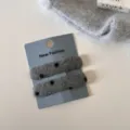 Gedetailleerd overzicht van grijze harige haarclips met stippen op kaart, gezellige winterstijl. - Paar clips / Grijze Stippen - Vierkant