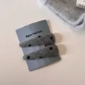 Gedetailleerd overzicht van de pluizige grijze stippen haarspeld met zachte textuur. - Paar clips / Grijze Stippen - Driehoek
