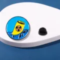Spilla smaltata ecologica con simbolo di radiazione nucleare e tartaruga marina. - CZ0119-1