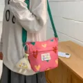 Cute pink canvas crossbody bag with heart pattern and green strap for daily student use. - Pink + Cheese Pendant