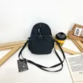 Black nylon mini crossbody bag, casual small backpack with strap, versatile daypack variant. - Black