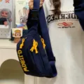 Stylish dark blue canvas chest bag with bright yellow zipper pulls and adjustable strap. - Blue