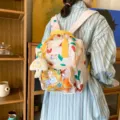 Cute heart pattern casual backpack with transparent front pocket and bright yellow handles. - Beige + Cheese Pendant