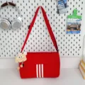Red canvas crossbody shoulder bag with three white stripes and cute plush pendant daily use. - With Long-Legged Cookie Pendant / Red