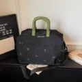 Large capacity travel duffel bag with green handles and cute embroidery for weekend trips. - Black